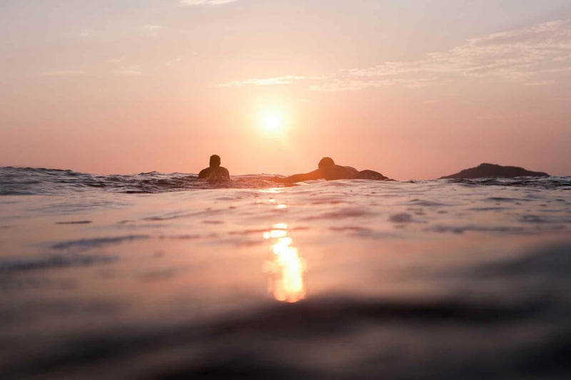 YWAM missionaries floating on surfboards in the sunset in Mexico