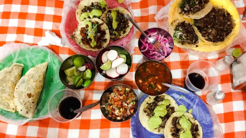 A table filled with delicious Mexican food such as quesadillas, tacos, and salsas