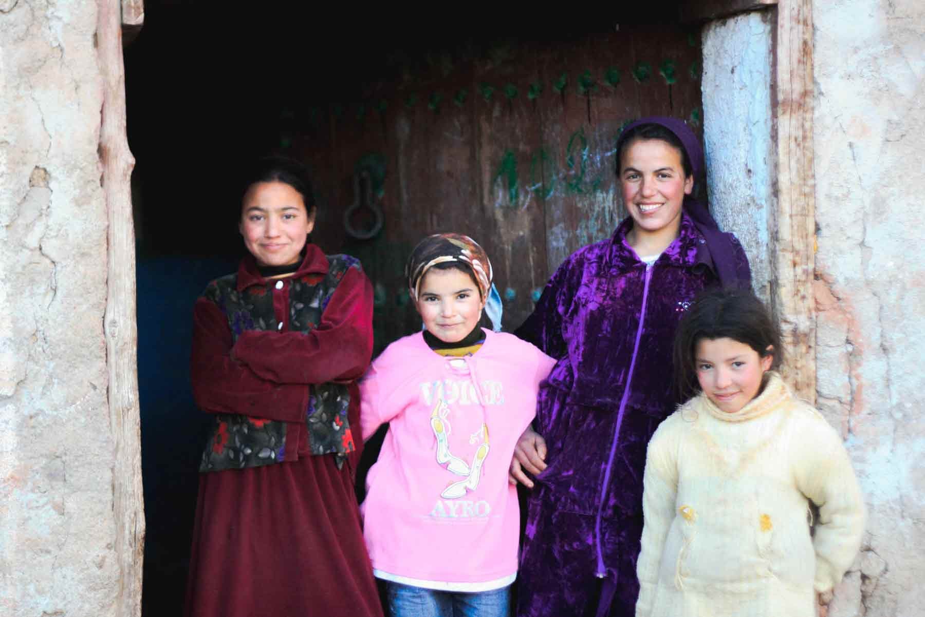 Middle Eastern women standing outside their home and smiling