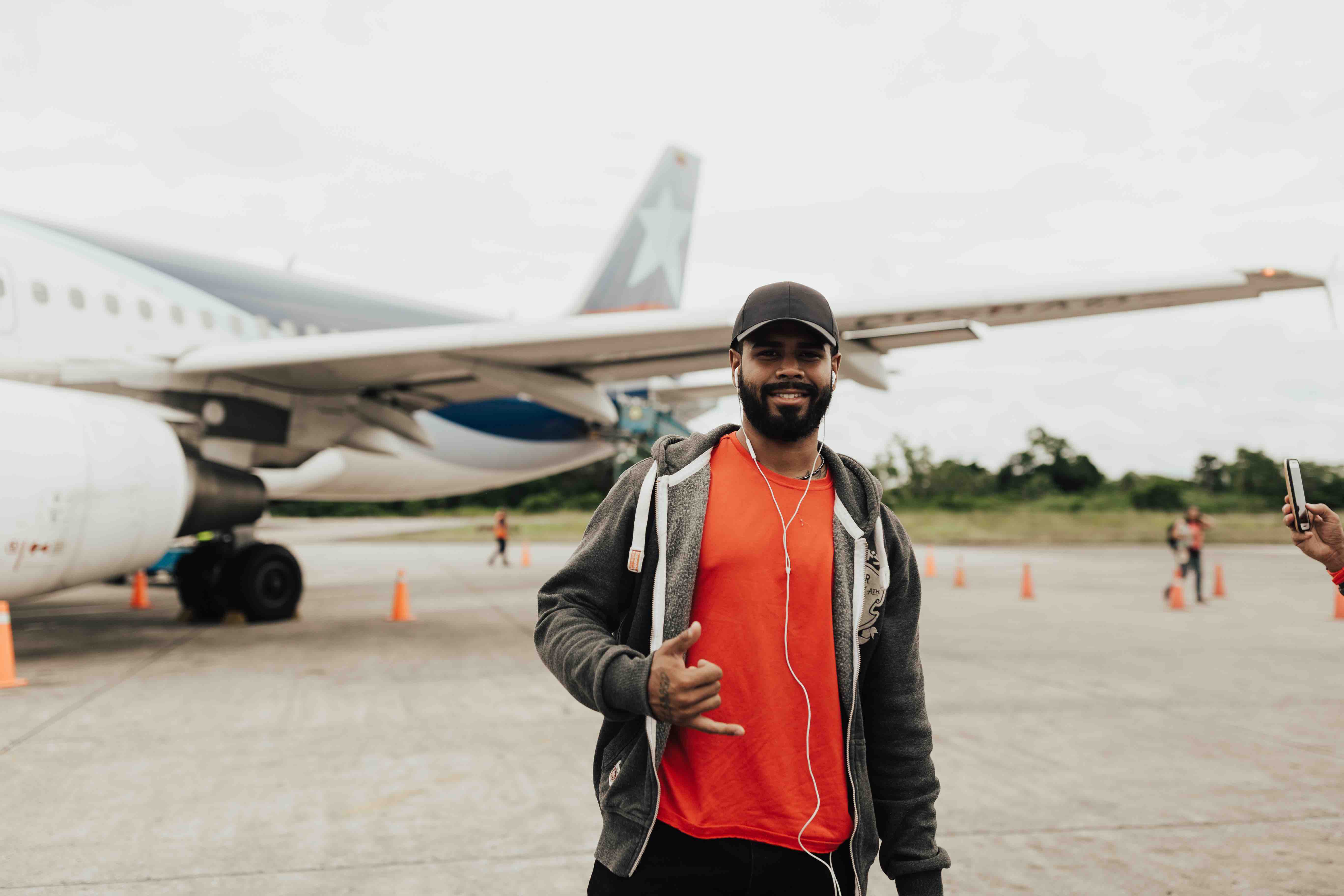 YWAM missionary standing in front of an airplane on the tarmac